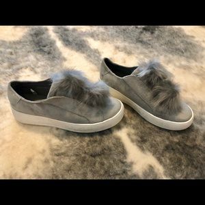Grey suede slip-ons with faux fur pom-poms
